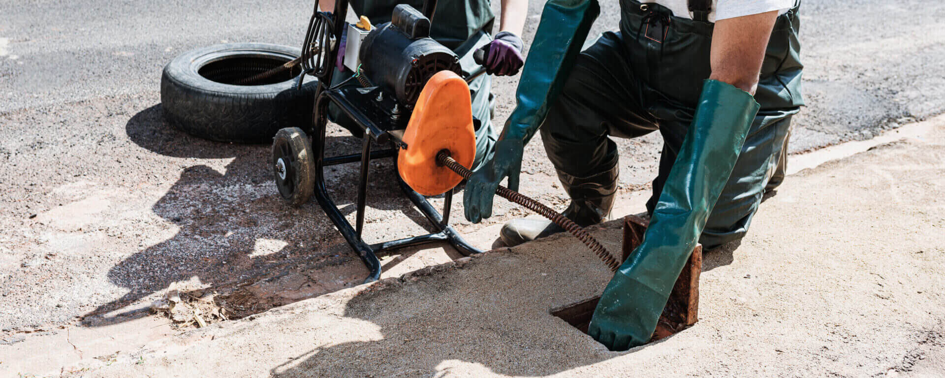 Professionals Unblocking Sewers On The Street Sidewalk. Electric Unclog